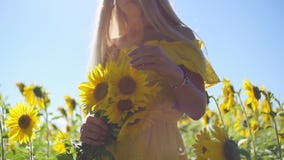 Ein junges Mädchen in einem gelben Kleid mit Sonnenblumen in ihren Händen Nahaufnahme stock video footage Ein junges Mädchen in einem gelben Kleid mit Sonnenblumen in ihren Händen Nahaufnahme stock video footage
