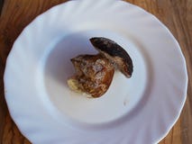 Ein kleiner gefrorener essbarer Pilz des Boletus in der weißen Platte stockfoto Ein kleiner gefrorener essbarer Pilz des Boletus in der weißen Platte stockfoto