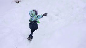 Ein kleines Kind geht in den Winter Park Spielendes und lächelndes Baby auf weißem flaumigem Schnee Aktiver Rest und Spiele stock footage Ein kleines Kind geht in den Winter Park Spielendes und lächelndes Baby auf weißem flaumigem Schnee Aktiver Rest und Spiele stock footage