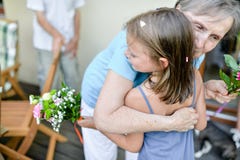 Ein kleines lachendes Mädchen in den Armen ihrer Großmutter, die ihre Wünsche während einer Geburtstagsfeier macht lizenzfreies stockfoto Ein kleines lachendes Mädchen in den Armen ihrer Großmutter, die ihre Wünsche während einer Geburtstagsfeier macht lizenzfreies stockfoto