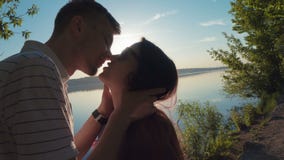 Ein liebevolles junges Paar, das auf umarmt und küsst stock video footage Ein liebevolles junges Paar, das auf umarmt und küsst stock video footage