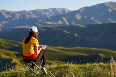 Ein Madchen Im Hintergrund Von Den Bergen Die Eine Landschaft Zeichnen Sitzt Mit Seinem Zuruck Draussen Malen Kazakhstan Berg Stockbild Bild Von Sitzt Hintergrund