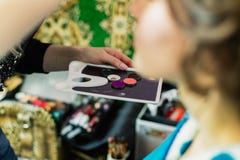 Ein Make-upwerkzeug in den Händen einer Frau, die Make-up tut stockfoto Ein Make-upwerkzeug in den Händen einer Frau, die Make-up tut stockfoto