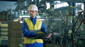 Ein Mann in der Arbeitskleidung kontrolliert Produktionsverfahren des Plastiks stock footage Ein Mann in der Arbeitskleidung kontrolliert Produktionsverfahren des Plastiks stock footage