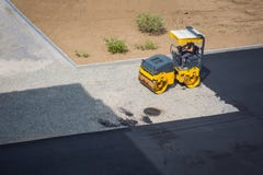 Ein Mann, der in einem minitruck sitzt, rammt Schutt für weitere Installation des Asphalts auf einer defekten Straße stockbild Ein Mann, der in einem minitruck sitzt, rammt Schutt für weitere Installation des Asphalts auf einer defekten Straße stockbild