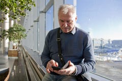 Ein Mann des Pensionsalters am Flughafen stockfotografie Ein Mann des Pensionsalters am Flughafen stockfotografie