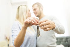 Ein reizendes junges Paar h?lt vor ihnen die Schl?ssel zu ihrer neuen Wohnung lizenzfreie stockbilder Ein reizendes junges Paar h?lt vor ihnen die Schl?ssel zu ihrer neuen Wohnung lizenzfreie stockbilder