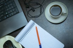 Ein sauberes Notizbuch auf dem Desktop, nahe bei dem Laptop, ein Tasse Kaffee, Kopfhörer stockbild Ein sauberes Notizbuch auf dem Desktop, nahe bei dem Laptop, ein Tasse Kaffee, Kopfhörer stockbild