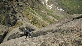Ein selbstloser Mann klettert zur Spitze der Klippe ohne ein Seil stock footage Ein selbstloser Mann klettert zur Spitze der Klippe ohne ein Seil stock footage