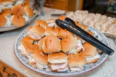 Ein Stapel von den zugebereiteten Truthahnsandwichen gestapelt auf einer Platte mit Zangen für Umhüllung lizenzfreies stockbild Ein Stapel von den zugebereiteten Truthahnsandwichen gestapelt auf einer Platte mit Zangen für Umhüllung lizenzfreies stockbild