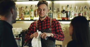 Ein stilvoller Barmixer hilft einem jungen Paar, eine Wahl von einem Cocktail zu treffen stock footage Ein stilvoller Barmixer hilft einem jungen Paar, eine Wahl von einem Cocktail zu treffen stock footage