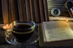 Ein Tasse Kaffee und auf dem Tisch ausgebreitet dem Buch lizenzfreies stockbild Ein Tasse Kaffee und auf dem Tisch ausgebreitet dem Buch lizenzfreies stockbild