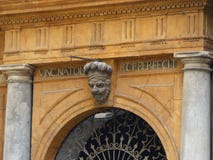 Eind van een deur van een oud paleis in Palermo met over het hoofd van een oude mens met een hoed, Sicilië, Italië royalty-vrije stock afbeelding Eind van een deur van een oud paleis in Palermo met over het hoofd van een oude mens met een hoed, Sicilië, Italië royalty-vrije stock afbeelding