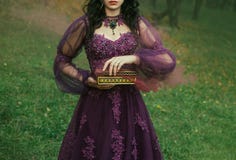 Eine dunkelhaarige junge Dame hält in ihren Händen offenes der Büchse der Pandora, den roten kastanienbraunen starken Nebel des Ü stockfotografie Eine dunkelhaarige junge Dame hält in ihren Händen offenes der Büchse der Pandora, den roten kastanienbraunen starken Nebel des Ü stockfotografie