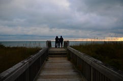 Eine Familie passt einen Sonnenaufgang am Strand auf lizenzfreies stockfoto Eine Familie passt einen Sonnenaufgang am Strand auf lizenzfreies stockfoto