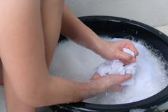Eine Frau wäscht Kleidung eigenhändig im Seifenwasser, auf weißem Hintergrund stockbilder Eine Frau wäscht Kleidung eigenhändig im Seifenwasser, auf weißem Hintergrund stockbilder