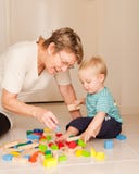 Eine Großmutter oder ein Kindermädchen spielt mit einem kleinen Jungen lizenzfreies stockfoto Eine Großmutter oder ein Kindermädchen spielt mit einem kleinen Jungen lizenzfreies stockfoto