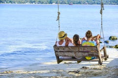 Eine Gruppe des Reisenden sitzend auf hölzernem Schwingen auf KohKham-Insel stockbild Eine Gruppe des Reisenden sitzend auf hölzernem Schwingen auf KohKham-Insel stockbild