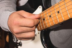 Eine Hand, die eine E-Gitarre mit einem Capo spielt lizenzfreie stockbilder Eine Hand, die eine E-Gitarre mit einem Capo spielt lizenzfreie stockbilder