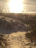 Eine hölzerne Straße unter den Dünen, die zu die Ostsee bei Sonnenuntergang in Klaipeda, Litauen führen stockbild Eine hölzerne Straße unter den Dünen, die zu die Ostsee bei Sonnenuntergang in Klaipeda, Litauen führen stockbild