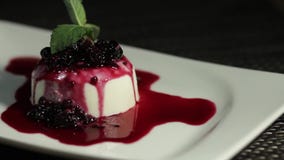 Eine langsame Gesamtlänge eines panna cota Kuchens auf einer drehenden Tabelle stock video footage Eine langsame Gesamtlänge eines panna cota Kuchens auf einer drehenden Tabelle stock video footage