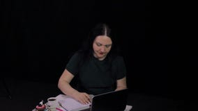 Eine nachdenkliche Frau an einem Tisch in einem Café arbeitet an einem Computer und an einem Getränkkaffee stock footage Eine nachdenkliche Frau an einem Tisch in einem Café arbeitet an einem Computer und an einem Getränkkaffee stock footage