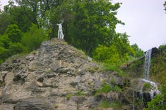 Eine Rotwildstatue nahe Wasserfall lizenzfreie stockfotografie Eine Rotwildstatue nahe Wasserfall lizenzfreie stockfotografie
