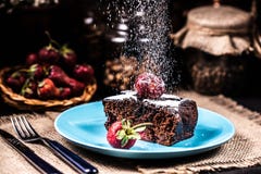 Eine Scheibe des Schokoladenkuchens mit Erdbeeren auf einer blauen Platte Sugar Snow stockbilder Eine Scheibe des Schokoladenkuchens mit Erdbeeren auf einer blauen Platte Sugar Snow stockbilder