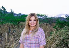 Eine schöne pralle Frau in einem kurzen Kleid Blond Mit einem schönen Lächeln Draußen auf dem Grasland und den Bergen im backgro lizenzfreie stockfotos Eine schöne pralle Frau in einem kurzen Kleid Blond Mit einem schönen Lächeln Draußen auf dem Grasland und den Bergen im backgro lizenzfreie stockfotos