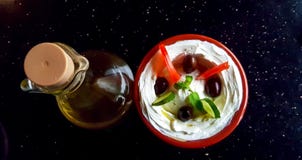 Eine Schüssel von labneh, von arabischem JogurtFrischkäsebad, mit Gemüse und einer Flasche Olivenöl auf einer dunklen Oberfläche lizenzfreies stockbild Eine Schüssel von labneh, von arabischem JogurtFrischkäsebad, mit Gemüse und einer Flasche Olivenöl auf einer dunklen Oberfläche lizenzfreies stockbild