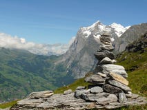 Eine Skulptur von Kieseln und von Schweizer Bergen im Hintergrund stockbilder Eine Skulptur von Kieseln und von Schweizer Bergen im Hintergrund stockbilder