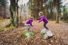 Eineiige Zwillinge springen von den Felsen im Wald auf dem Wandern stockbilder Eineiige Zwillinge springen von den Felsen im Wald auf dem Wandern stockbilder