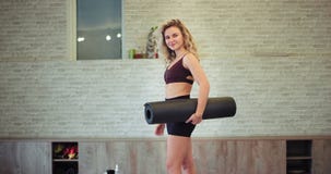 In einer schönen Dame des modernen aeroben Studios mit einem geeigneten Körper, der gerade zur Kamera charismatisch sie a halten In einer schönen Dame des modernen aeroben Studios mit einem geeigneten Körper, der gerade zur Kamera charismatisch sie a halten