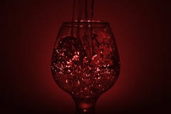 Einfaches Stilllebenfoto Whiskyglas-, Wasserstrahl- und schwachemrotes L stockfotos Einfaches Stilllebenfoto Whiskyglas-, Wasserstrahl- und schwachemrotes L stockfotos