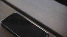 Eingehender Anruf am schwarzen intelligenten Telefon auf Holztisch Beantworten eines eingehenden Anrufs am intelligenten Telefon Eingehender Anruf am schwarzen intelligenten Telefon auf Holztisch Beantworten eines eingehenden Anrufs am intelligenten Telefon