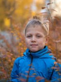 Einsamer Junge mit einem Lächeln in Herbst Park lizenzfreie stockfotos Einsamer Junge mit einem Lächeln in Herbst Park lizenzfreie stockfotos