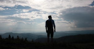 Einsamer Weg in den Bergen Betrachten Sie von hinten einem Mann mit dem Rucksack, der vor schöner Berglandschaft steht und stock video Einsamer Weg in den Bergen Betrachten Sie von hinten einem Mann mit dem Rucksack, der vor schöner Berglandschaft steht und stock video