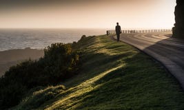 Einziges Mädchen geht entlang Küste clifftop Straße Stockbild Einziges Mädchen geht entlang Küste clifftop Straße Stockbild