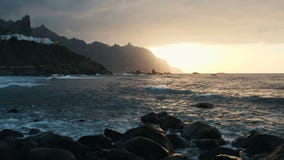 El abej?n vuela sobre las olas oce?nicas que se estrellan en rocas y que roc?an en luz hermosa de la puesta del sol en la playa d almacen de video El abej?n vuela sobre las olas oce?nicas que se estrellan en rocas y que roc?an en luz hermosa de la puesta del sol en la playa d almacen de video