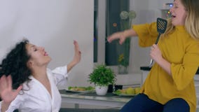 El abrazo amistoso, las muchachas alegres se divierte y canta en espátula de la cocina en el tiempo libre almacen de metraje de vídeo El abrazo amistoso, las muchachas alegres se divierte y canta en espátula de la cocina en el tiempo libre almacen de metraje de vídeo