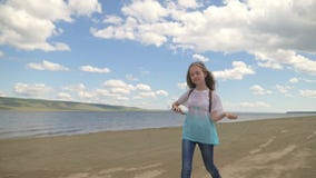 El adolescente salta a lo largo de la playa y escucha la música almacen de video El adolescente salta a lo largo de la playa y escucha la música almacen de video