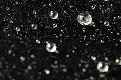 El agua brillante de lujo magnífica gotea en el terciopelo negro imagen de archivo libre de regalías El agua brillante de lujo magnífica gotea en el terciopelo negro imagen de archivo libre de regalías