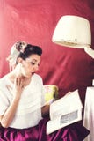 El ama de casa del vintage lee la revista en salón de belleza imágenes de archivo libres de regalías El ama de casa del vintage lee la revista en salón de belleza imágenes de archivo libres de regalías