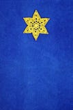 El amarillo hizo a ganchillo la estrella de Belén en fondo azul del terciopelo foto de archivo El amarillo hizo a ganchillo la estrella de Belén en fondo azul del terciopelo foto de archivo