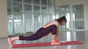 El atleta de sexo femenino joven hace ejercicio que estira difícil en la estera del gimnasio mientras que entrena en el gimnasio foto de archivo libre de regalías El atleta de sexo femenino joven hace ejercicio que estira difícil en la estera del gimnasio mientras que entrena en el gimnasio foto de archivo libre de regalías