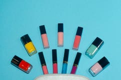 El bolso cosmético de la mujer, compone productos de belleza en fondo azul Lápices labiales rojos, rosados, magentas y azules Sis imágenes de archivo libres de regalías El bolso cosmético de la mujer, compone productos de belleza en fondo azul Lápices labiales rojos, rosados, magentas y azules Sis imágenes de archivo libres de regalías