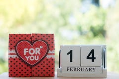 El calendario de madera, el 14 de febrero, consiste en una caja de corazones rojos que se escriban para usted, colocada de lado a imagen de archivo El calendario de madera, el 14 de febrero, consiste en una caja de corazones rojos que se escriban para usted, colocada de lado a imagen de archivo