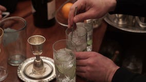 El camarero de sexo masculino revuelve el hielo con un cóctel en un vidrio metrajes El camarero de sexo masculino revuelve el hielo con un cóctel en un vidrio metrajes