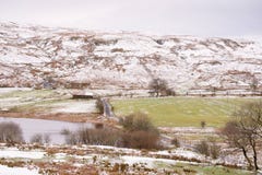 El camino congelado del invierno con nieve ligera en las colinas y el lago echan a un lado imágenes de archivo libres de regalías El camino congelado del invierno con nieve ligera en las colinas y el lago echan a un lado imágenes de archivo libres de regalías