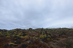El campo de lava con hielo capsuló las montañas en el fondo fotos de archivo libres de regalías El campo de lava con hielo capsuló las montañas en el fondo fotos de archivo libres de regalías